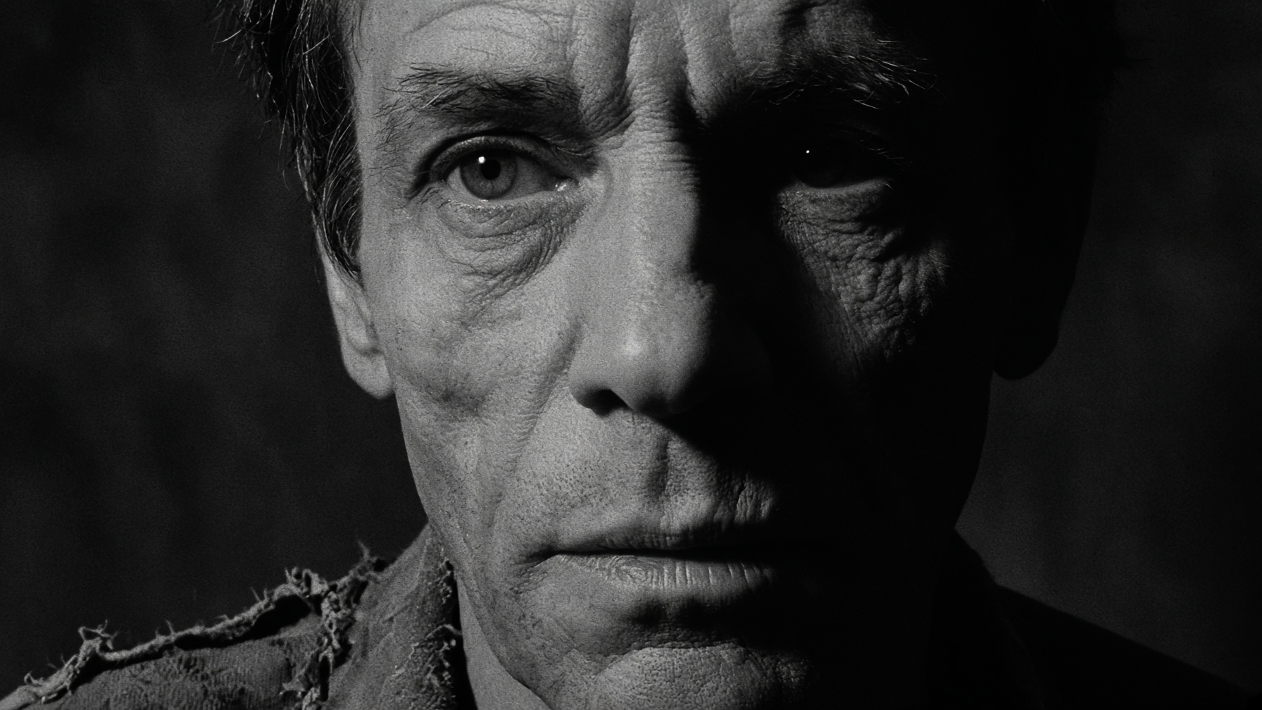 A gaunt face, half lost in shadow.